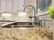 Close-up of a stainless steel kitchen sink with granite countertops and a decorative faucet at 1045 River Pt, Suwanee, GA 30024