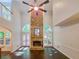 Spacious living room with a stone fireplace, a ceiling fan and backyard views at 1045 River Pt, Suwanee, GA 30024