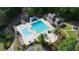 Aerial view showcases a luxurious pool area, pool house, and manicured landscape at 1045 River Pt, Suwanee, GA 30024
