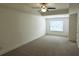 Spacious bedroom with neutral carpet, ceiling fan, and a large window with blinds at 340 Auburn Valley Way, Auburn, GA 30011