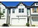 Charming townhome with a white brick exterior, garage, black accents, and well-manicured landscaping at 340 Auburn Valley Way, Auburn, GA 30011