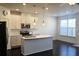Bright kitchen with stainless appliances, center island, and dark hardwood floors at 340 Auburn Valley Way, Auburn, GA 30011