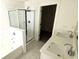 Bright bathroom featuring double vanity, bathtub, and glass-enclosed shower at 340 Auburn Valley Way, Auburn, GA 30011