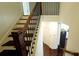 Staircase with wood treads and dark railing leading to the kitchen with stainless appliances at 340 Auburn Valley Way, Auburn, GA 30011