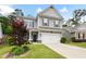 Two-story home with gray siding, two-car garage, manicured lawn, and vibrant foliage at 129 Prominence Ct, Canton, GA 30114