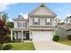 Charming two-story home featuring a well-manicured lawn, gray siding and shutters and a two-car garage at 129 Prominence Ct, Canton, GA 30114