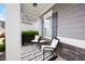 Relaxing porch with black-and-white striped rug, cozy chairs, and manicured greenery at 129 Prominence Ct, Canton, GA 30114