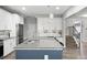 Kitchen features a large granite island with bar seating, white cabinets, stainless steel appliances and stairs leading to another floor at 129 Prominence Ct, Canton, GA 30114