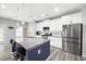 Bright kitchen with stainless steel refrigerator, white cabinetry, island with bar stool seating and stainless steel appliances at 129 Prominence Ct, Canton, GA 30114