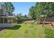 This fenced backyard features a lush green lawn and playset for entertainment at 4824 Dunwoody Station Dr, Atlanta, GA 30338