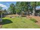 Large fenced backyard features a lawn and a swing set, perfect for children to play at 4824 Dunwoody Station Dr, Atlanta, GA 30338