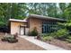 Exterior view of a modern building nestled among tall trees with wooden accents and lush landscaping at 4824 Dunwoody Station Dr, Atlanta, GA 30338