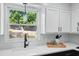 Bright kitchen featuring a sink with a window view and white cabinets at 4824 Dunwoody Station Dr, Atlanta, GA 30338
