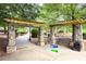 The park entrance has stone pillars, a wooden trellis, a park bench, and 'Live Music' sign at 4824 Dunwoody Station Dr, Atlanta, GA 30338