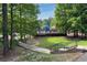 Wood deck playground sits among the trees with stairs, metal railings, and grass in a park setting at 4824 Dunwoody Station Dr, Atlanta, GA 30338