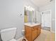 Bathroom featuring a vanity with a sink, toilet, decorative light fixture and an open doorway at 620 Stickley Oak Way, Woodstock, GA 30189