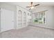 Sunlit bedroom featuring built-in shelves, a window view and a ceiling fan at 620 Stickley Oak Way, Woodstock, GA 30189