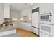 Well-lit kitchen featuring white cabinetry, stainless appliances, granite counters and hardwood flooring at 700 Park Regency Ne Pl # 1203, Atlanta, GA 30326