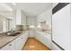 Bright kitchen featuring white cabinets, stainless appliances, granite countertops, and hardwood floors at 700 Park Regency Ne Pl # 1203, Atlanta, GA 30326