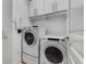 Convenient laundry room featuring a washer, dryer, and overhead cabinets for storage at 3286 Northside Nw Pkwy # 903, Atlanta, GA 30327
