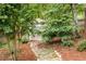 Tranquil backyard landscape featuring a dry creek bed and a charming lattice-covered garden shed at 427 Picketts Lake Dr, Acworth, GA 30101
