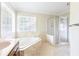 Bathroom features a soaking tub, glass enclosed shower, and corner windows at 427 Picketts Lake Dr, Acworth, GA 30101