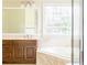 Bathroom boasts a soaking tub, large window, and wooden vanity at 427 Picketts Lake Dr, Acworth, GA 30101