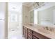 Bright bathroom featuring double sinks, white tile flooring, and ample counter space at 427 Picketts Lake Dr, Acworth, GA 30101