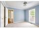 Light-filled bedroom with a large window, plush carpet, neutral paint, and a ceiling fan at 427 Picketts Lake Dr, Acworth, GA 30101