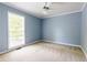 Bright bedroom features neutral paint, plush carpet, a ceiling fan, and a large window with backyard views at 427 Picketts Lake Dr, Acworth, GA 30101