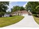 Spacious home featuring a two-car garage and an expansive driveway, surrounded by lush greenery at 427 Picketts Lake Dr, Acworth, GA 30101
