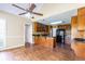 Open-concept kitchen with hardwood floors, wood cabinets, granite counters, and modern black appliances at 427 Picketts Lake Dr, Acworth, GA 30101
