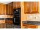 Kitchen featuring custom cabinets, granite countertops, tile backsplash, and built-in stainless appliances at 427 Picketts Lake Dr, Acworth, GA 30101