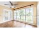 Bright sunroom with hardwood floors, ceiling fan, and large windows overlooking the backyard at 427 Picketts Lake Dr, Acworth, GA 30101