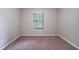 Bedroom with neutral colored walls and carpet features a bright window with wooded outdoor view at 5810 Tree Line Ter, Lithonia, GA 30058