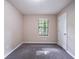 Bedroom with neutral colored walls and carpet features a bright window and white door at 5810 Tree Line Ter, Lithonia, GA 30058