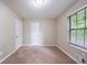 Bedroom with two white doors, neutral paint, carpet, and a window with blinds at 5810 Tree Line Ter, Lithonia, GA 30058