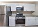 Modern kitchen featuring stainless steel appliances, granite countertops, and white cabinets at 5810 Tree Line Ter, Lithonia, GA 30058