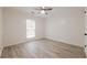 Cozy bedroom with light wood floors, a ceiling fan, and natural lighting at 9985 Lake Forest Way, Roswell, GA 30076