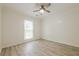 Bright bedroom featuring light wood flooring, a ceiling fan, and a large window at 9985 Lake Forest Way, Roswell, GA 30076