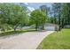 Exterior view of a single-Gathering home with a long driveway and mature trees at 9985 Lake Forest Way, Roswell, GA 30076