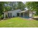 Charming single-Gathering home with well-maintained lawn, carport, and stone facade accents at 9985 Lake Forest Way, Roswell, GA 30076