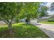 Well-maintained home with green lawn, mature trees, long driveway, and stone accents at 9985 Lake Forest Way, Roswell, GA 30076