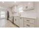 Updated kitchen featuring modern appliances, white cabinets, quartz countertops, and stainless steel fixtures at 9985 Lake Forest Way, Roswell, GA 30076