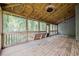 Charming screened porch with wooden floors, a swing, and views of lush greenery at 9985 Lake Forest Way, Roswell, GA 30076