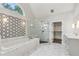 Luxurious bathroom features a soaking tub, glass-enclosed shower, marble finishes and geometric accent wall at 110 Keswick Way, Alpharetta, GA 30022
