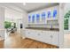 Butler pantry features stylish cabinetry with glass fronts, granite countertops, and a sink at 110 Keswick Way, Alpharetta, GA 30022