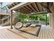 Relaxing covered patio with comfortable seating, hanging chair, outdoor TV, and ceiling fan, perfect for entertaining at 110 Keswick Way, Alpharetta, GA 30022