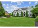 Charming two-story home featuring a lush green lawn, mature trees, and elegant architectural details at 110 Keswick Way, Alpharetta, GA 30022