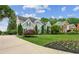 A beautiful home with landscaped lawn, flowering plants and a winding driveway at 110 Keswick Way, Alpharetta, GA 30022
